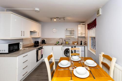 a kitchen and dining room with a table and chairs at Glastonbury Centre 2 Bed with on street Parking in Glastonbury