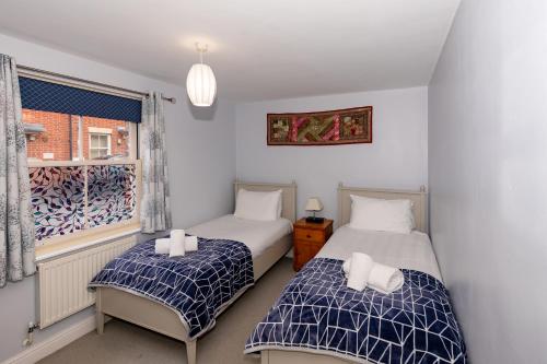 two beds in a room with a window at Glastonbury Centre 2 Bed with on street Parking in Glastonbury