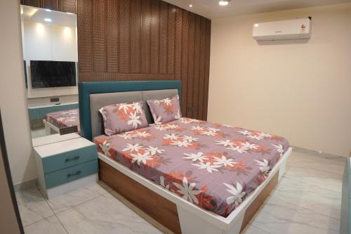 a bedroom with a bed with a blue headboard at Apna Ghar in Jaipur