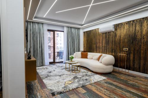 ein Wohnzimmer mit einer weißen Couch und einem Tisch in der Unterkunft VNS LUXURY STAY apartment in Târgovişte