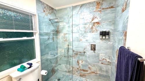 a bathroom with a shower with a glass door at Escape near to Siesta Key with Hot Tub, BBQ, and Fire pit in Sarasota
