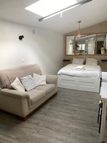 een slaapkamer met een bed, een bank en een spiegel bij Like a Local Guest House in Ericeira