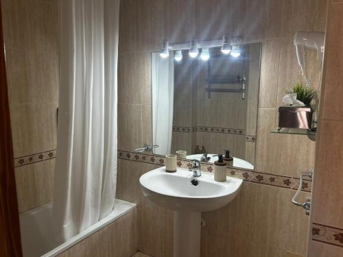 une salle de bain avec un lavabo, une douche et un miroir dans l'établissement Casa Gisbert Centro histórico Parking Free, à Carthagène