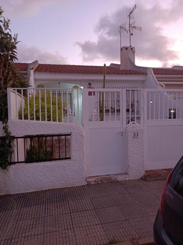 a white house with a white gate and a driveway at El Rincón del Sotillo beach in Los Alcázares