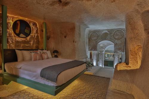 a bedroom with a bed in a stone room at Eka Cave Maison Authentic Cave Boutique Hotel in Cappadocia Village in Nevşehir