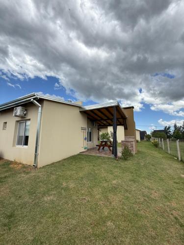 een klein huis met een picknicktafel in de tuin bij Complejo Aires del Cielo in San José