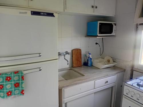 a kitchen with a sink and a microwave at Valeria del Mar Apartment in Valeria del Mar