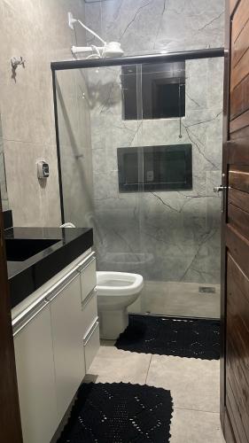 een badkamer met toilet en glazen douche bij Alphaville Pousada e Hostel in Bonito