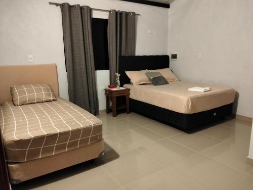 a bedroom with two beds in a room at Posada El Encuentro in Atyrá
