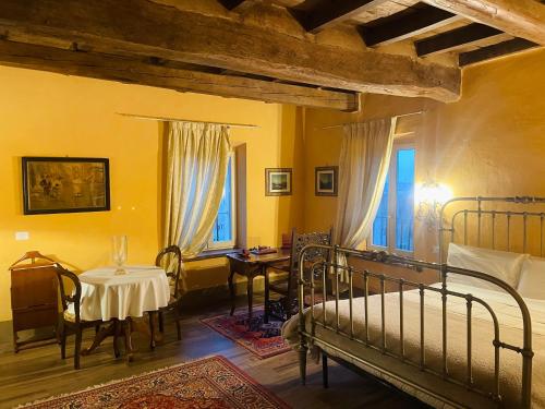 a bedroom with a bed and a table and windows at BORGO VILLA VALENTINI in Scandiano