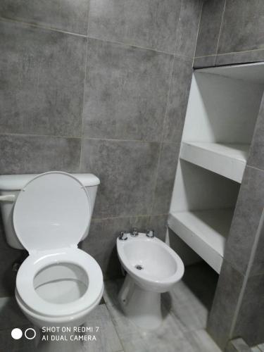 a bathroom with a white toilet and a sink at Departamentos Necochea in Necochea