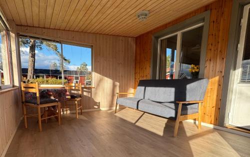 a screened in porch with a couch and a table at Holiday Home Skoaffär in Lakene