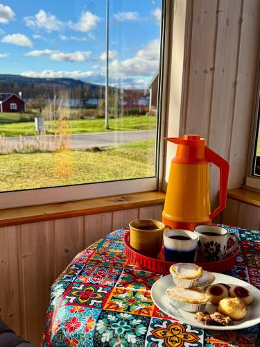 a table with a plate of food on a table with a window at Holiday Home Skoaffär in Lakene