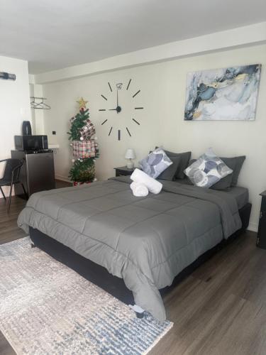 una camera da letto con un grande letto con un orologio sul muro di La Aurelia Resort a Lowlands