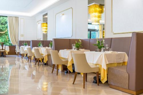 a dining room with white tables and chairs at Hotel President Terme in Abano Terme