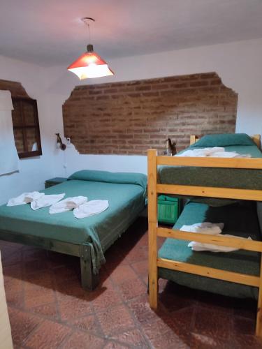 a bedroom with two bunk beds and a brick wall at maemm el castillto in Mina Clavero