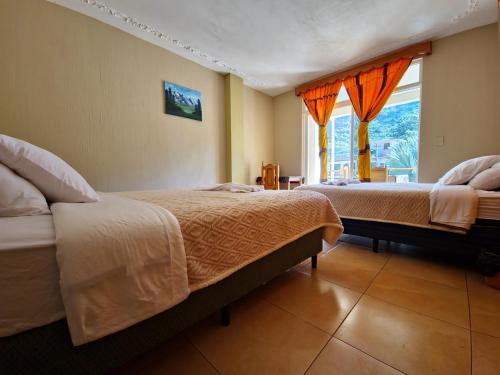 een slaapkamer met twee bedden en een raam bij Casa de Alondras in Panajachel