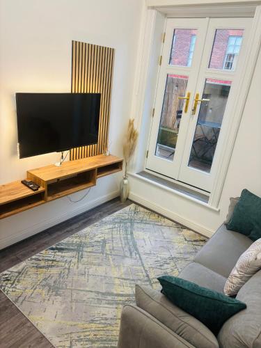 a living room with a couch and a flat screen tv at The Luxe Haven Penthouse - Sleeps 4 Apartment Nottingham City Centre in Nottingham