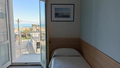 een kamer met een bed en een balkon met uitzicht bij Hotel Ariston Imperial in Porto Garibaldi