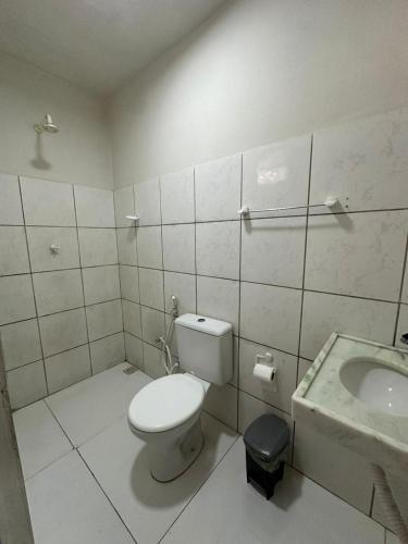 a bathroom with a toilet and a sink at Preá Beach Flat in Cruz