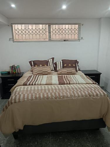 a large bed in a bedroom with a window at Protea Place Cottage in La Mercy