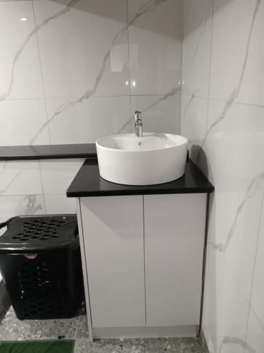 a white bathroom with a sink and a stove at Protea Place Cottage in La Mercy