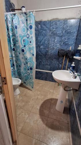 a bathroom with a shower curtain and a sink at Casa de campo Pajarito in San Fernando del Valle de Catamarca