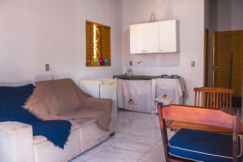 een woonkamer met een bank en een keuken bij Chalé Azul Aurora in Manhã