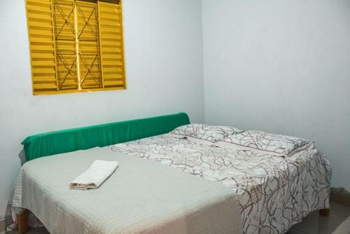 een slaapkamer met een bed met een handdoek erop bij Chalé Azul Aurora in Manhã