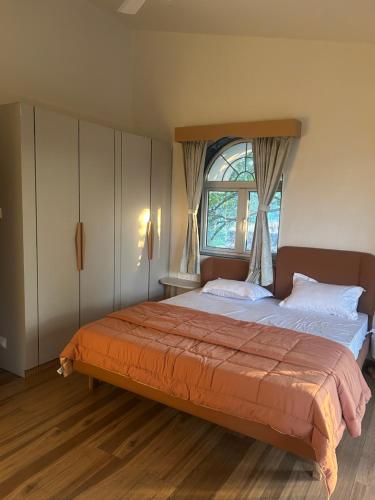 a bedroom with a large bed with a window at Atishay Villa I 4BHK I Pure veg I Pvt Pool & lawn in Lonavala