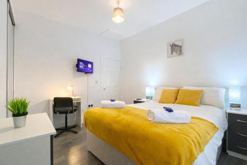 a bedroom with a large bed with towels on it at Emerald Living - Hanley, Stoke-on-Trent, sleeps 5, with free parking! in Stoke on Trent