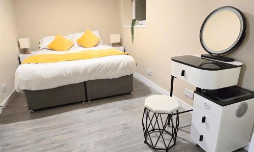 een slaapkamer met een bed met een spiegel en een kruk bij One Old Creamery in Sandhead