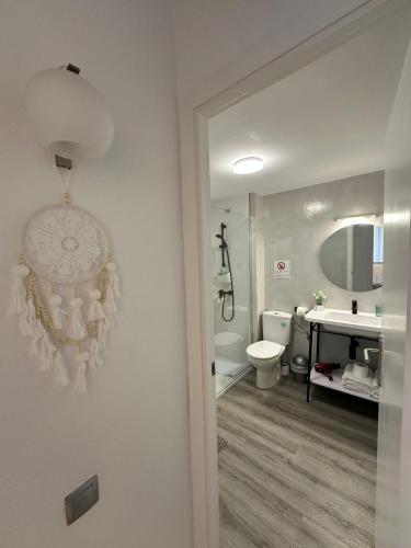 a white bathroom with a sink and a toilet at Apartamento Carles Buïgas in Salou