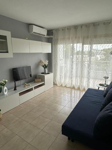 a living room with a couch and a tv at Apartamento Carles Buïgas in Salou