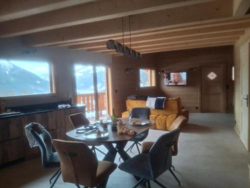 a living room with a table and chairs and a couch at Chalet la Fiolaz in Châtel