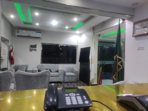 a room with a table with a remote control on it at تاج الملكه للشقق المخدومة in Ḑirs