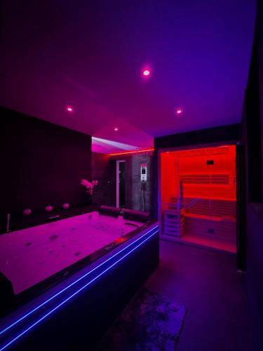 a room with a tub with purple and red lights at L' Instant Se Crée in Oignies