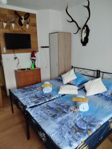 ein Schlafzimmer mit einem Bett mit einer blauen Bettdecke in der Unterkunft Seba in Jugów