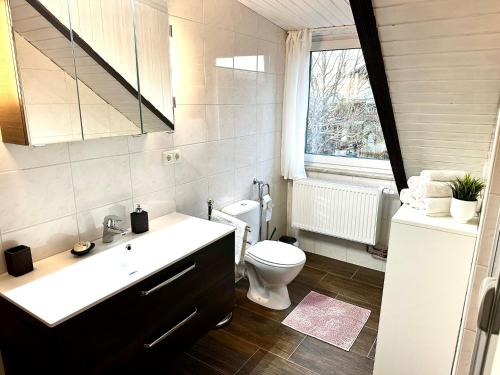 a bathroom with a sink and a toilet and a window at LUMI Living in Schlüsselfeld