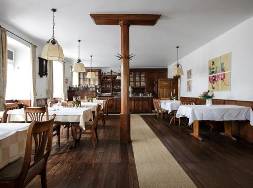 ein Esszimmer mit weißen Tischen und Holzböden in der Unterkunft Hotel Scheidels Kranz in Kenzingen