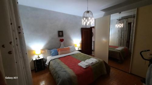 Schlafzimmer mit einem Bett mit einer roten und grünen Decke in der Unterkunft Casa Kelly in Luni