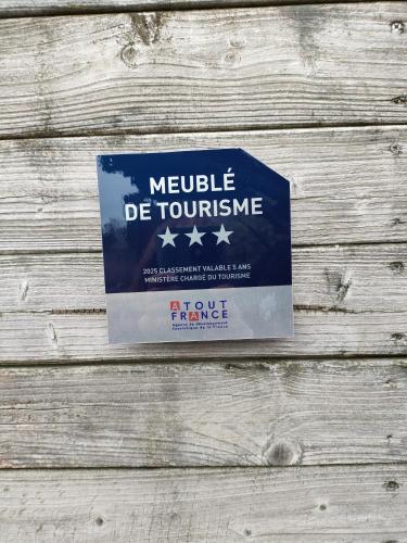 un cartello su un muro di legno con quattro stelle di Interludes Normands a Ver-sur-Mer