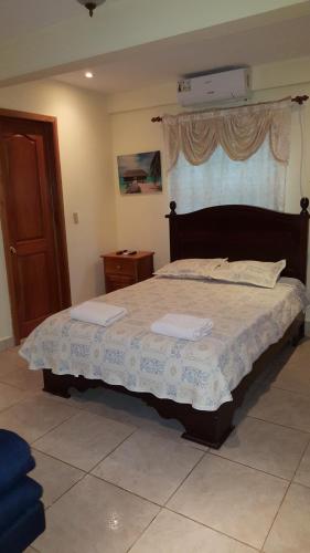 a bedroom with a large bed with a wooden headboard at Hostal Bocas Tropical Paradise in Bocas del Toro
