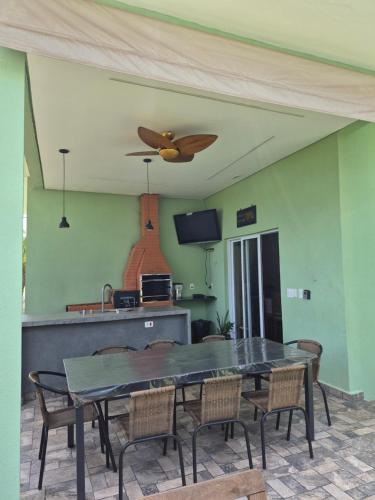 een eetkamer met een tafel en een plafondventilator bij Refugio 4 suites com ar condicionado e piscina in Águas de Santa Barbara