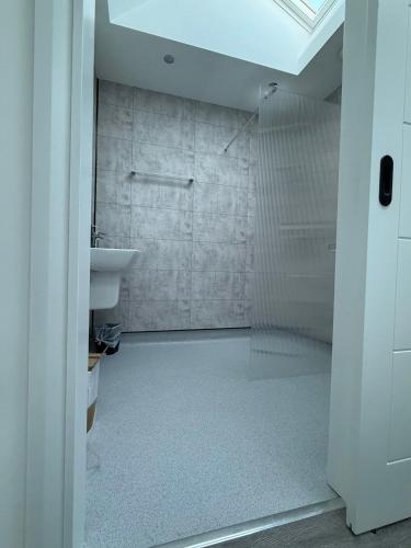 a bathroom with a glass shower and a sink at Black Dub Cottage in Allonby