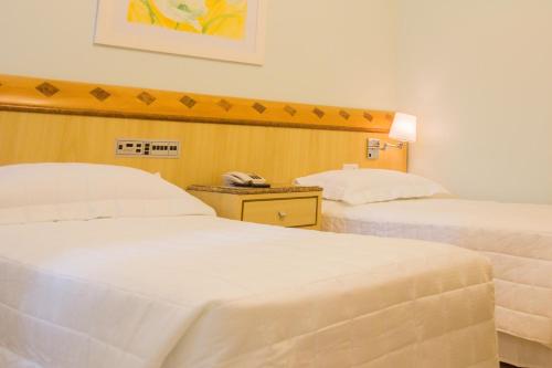 a hotel room with two beds and a telephone at L'Opera Hotel in Sao Paulo