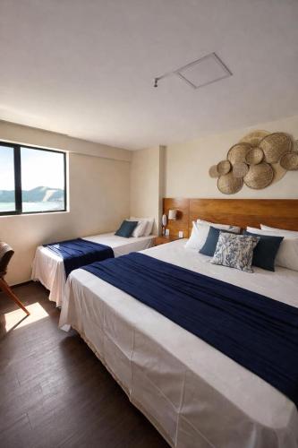 a hotel room with two beds and a window at Exclusive Natal Plaza - Vista Mar - Ponta Negra in Natal