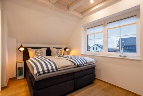 een slaapkamer met een bed en een raam bij Reethaus Nordlicht A Top-class in Dranske