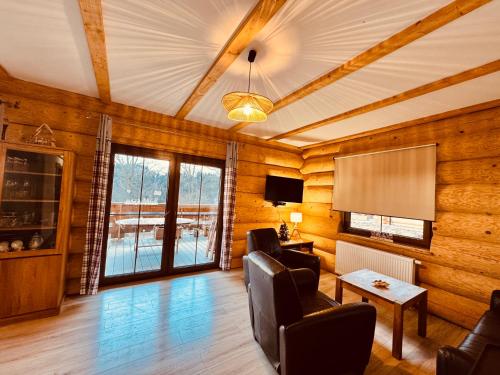 een woonkamer met houten wanden en een flatscreen-tv bij Chata Santa Claus - Rudolf i Pyszałek GÓRY SOWIE in Sokolec