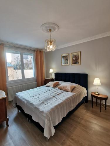 une chambre avec un grand lit et un lustre dans l'établissement Independent studio 12 min from Paris, à Deuil-la-Barre
